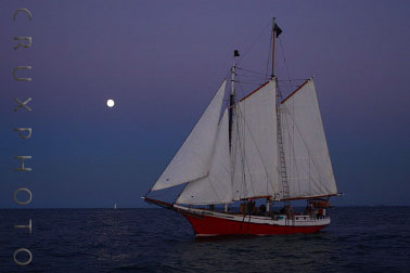 A Beautiful Sailboat and the Moon at Sunset on Lake Michigan.  Copyright Nate Young and Crux Photo